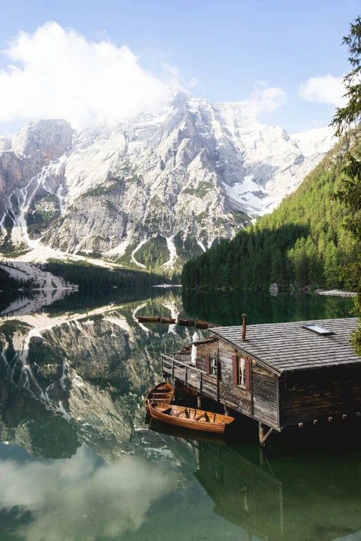 a house boat tied up to a dock in a mountain lake