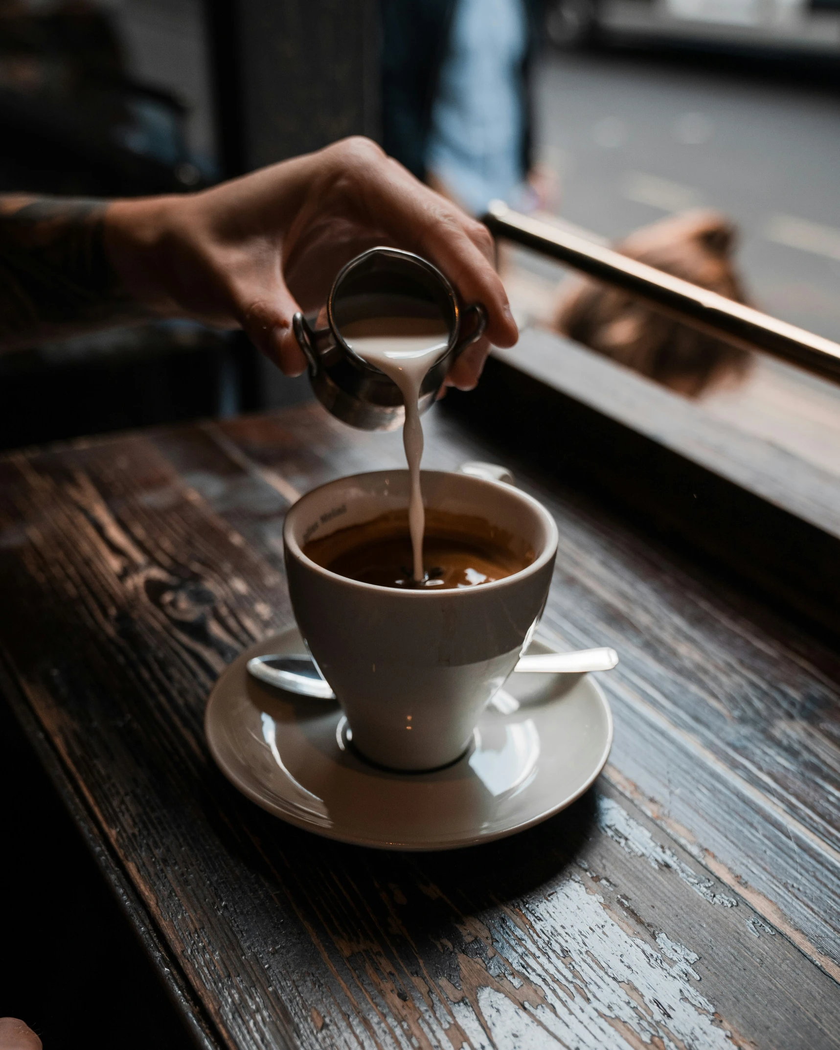 a person is pouring coffee into a cup