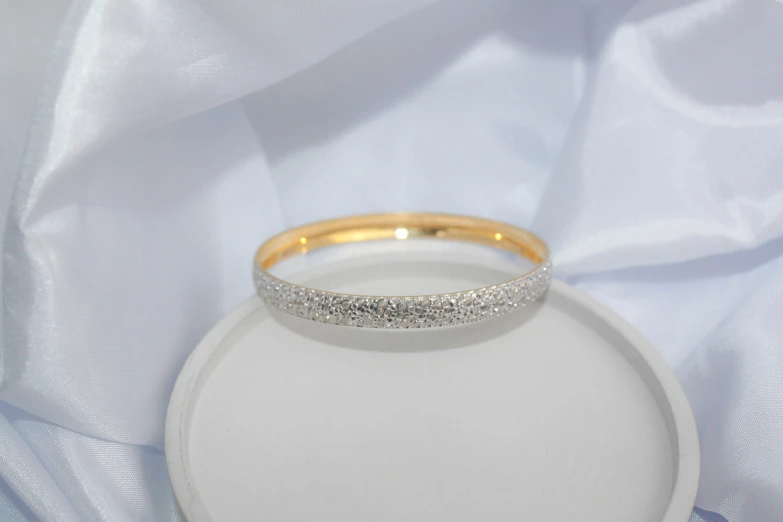 a ring with silver sparkles on top on a white plate