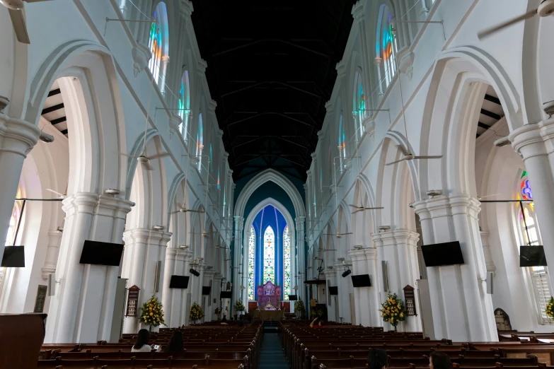 an empty cathedral with pews and stained glass windows