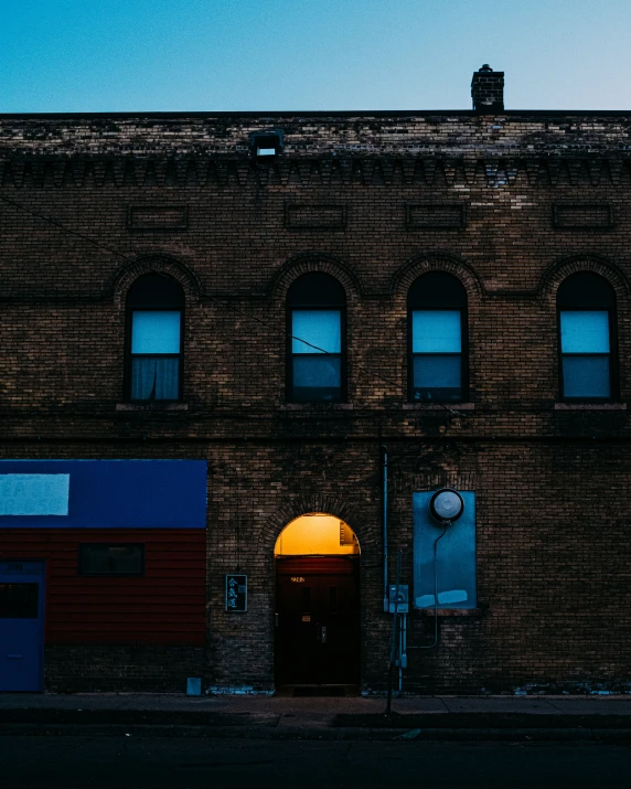 the side view of an old brick building with a clock on the door