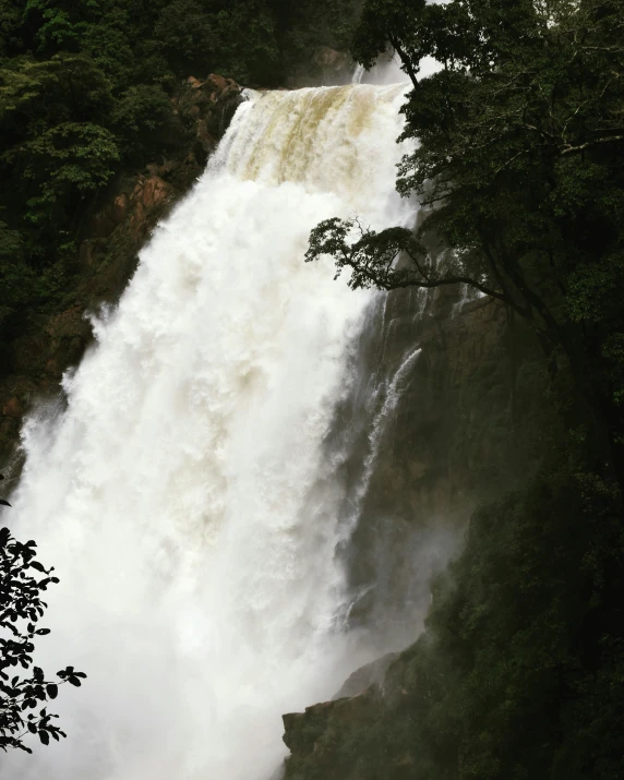 a large waterfall with a few people standing in front