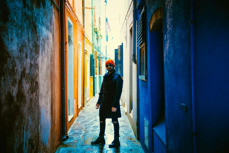 a woman standing in an alleyway between two buildings