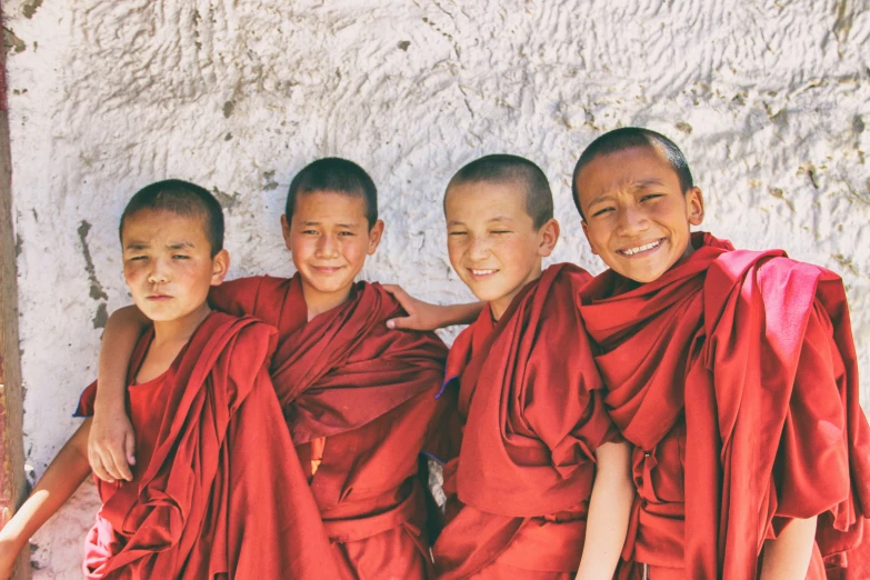 four boys standing side by side with their arms around one another