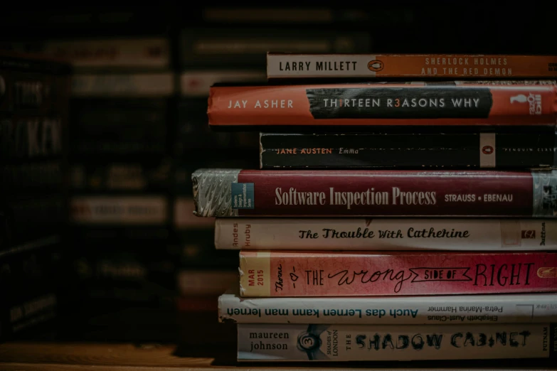a stack of books in front of a shelf full of books
