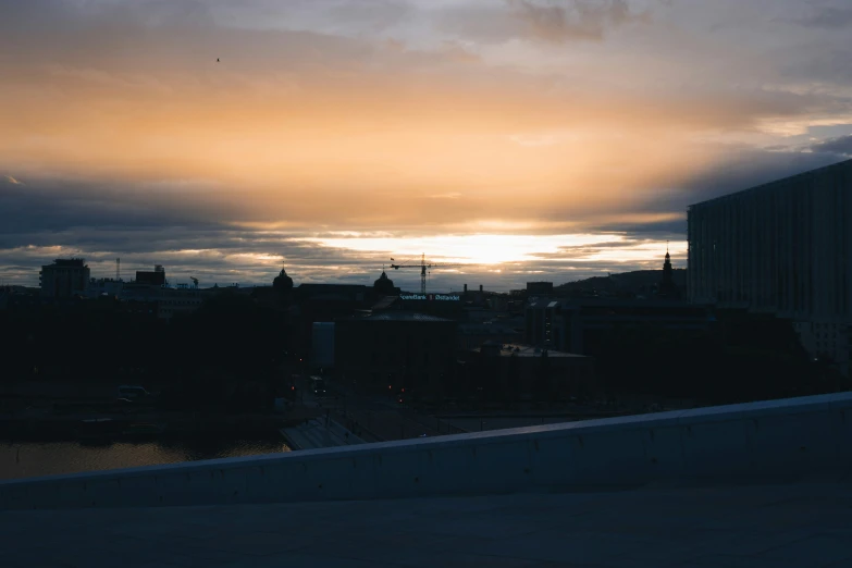 some very dark buildings at dusk by the water