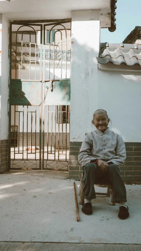 an old man sitting in front of a building