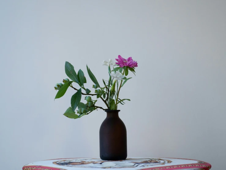 two vases of flowers on an old cushion