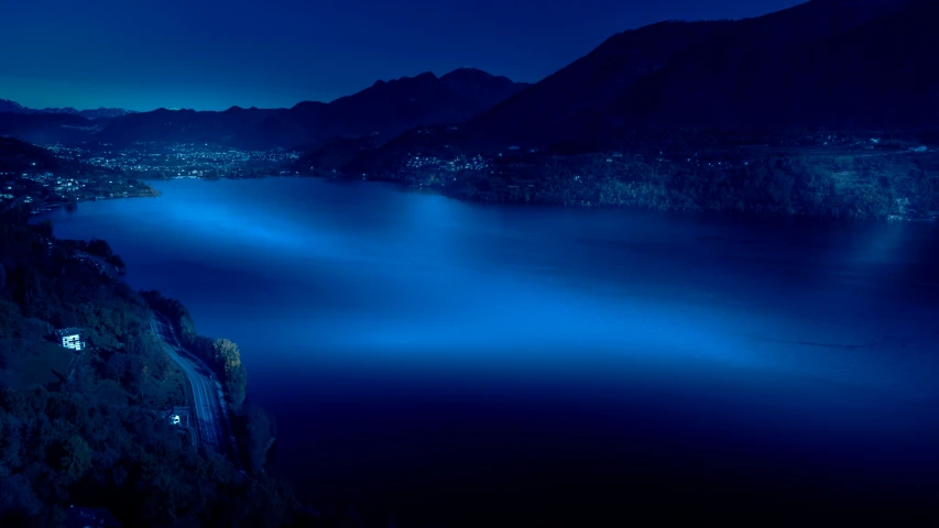 a lake with lights on the water at night