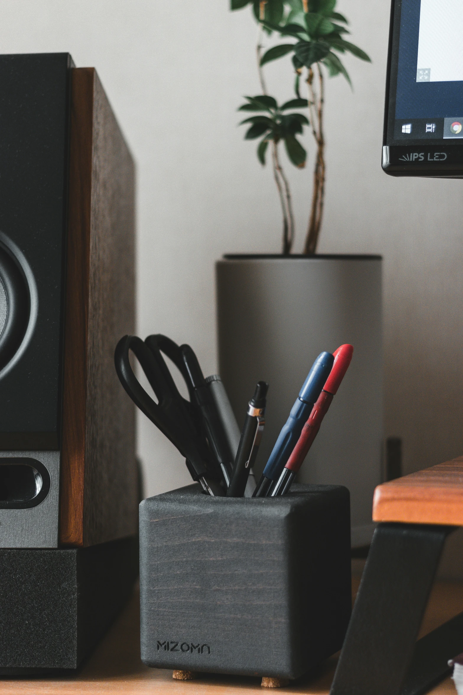 a desktop with a telephone, speaker and pens and scissors