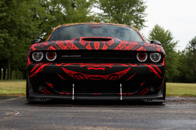 the hood on a car covered in red artistic paint