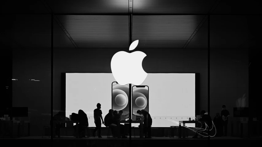 people gathered in front of an apple sign