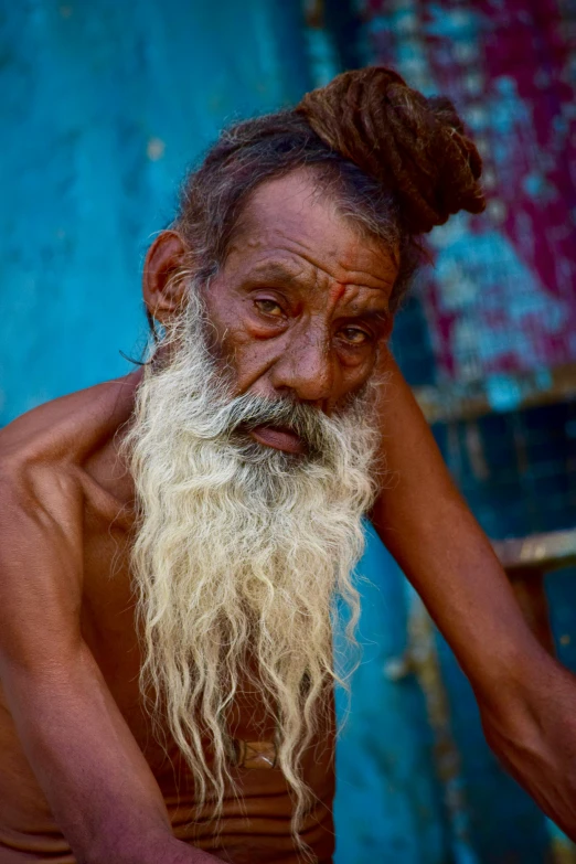 an old man with a long white beard is sitting