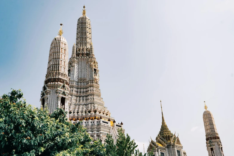 the two towers are surrounded by trees against the blue sky