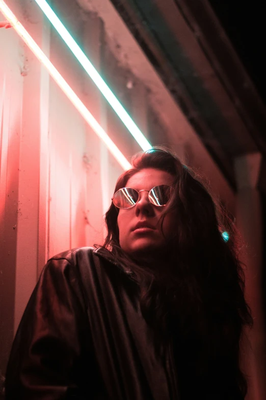 woman in glasses standing near a building in the dark