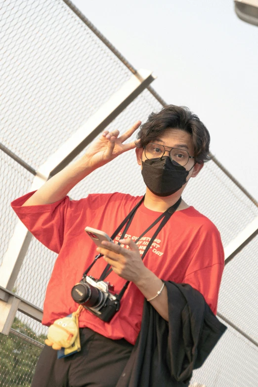 a man in glasses with a face mask looking at a cellphone