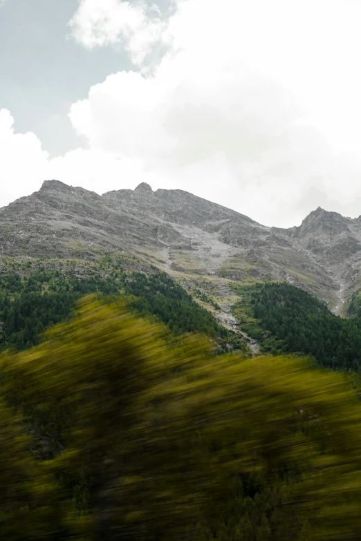 the mountains are very high as seen by a moving train