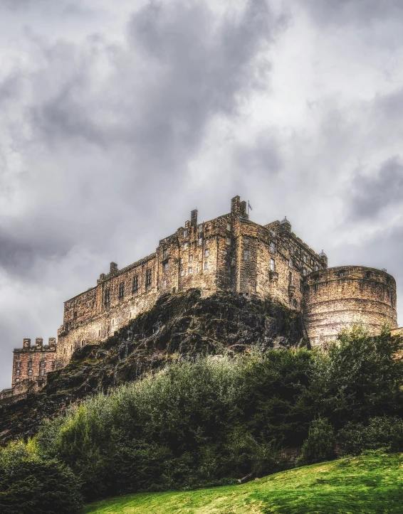 castle on a hill surrounded by trees in cloudy weather