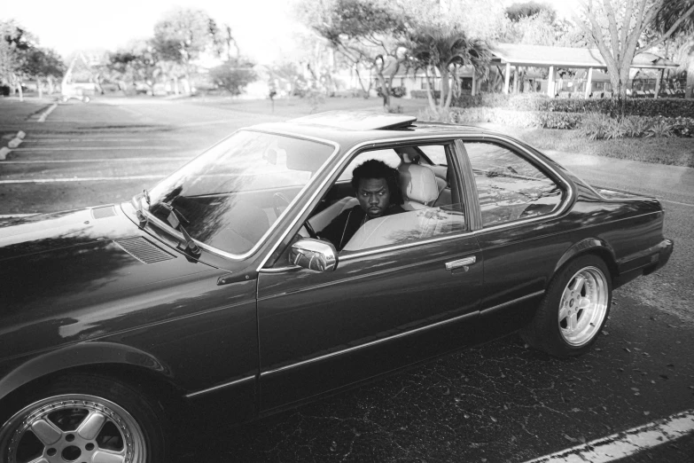 a woman sitting in a black cab parked on the side of a road