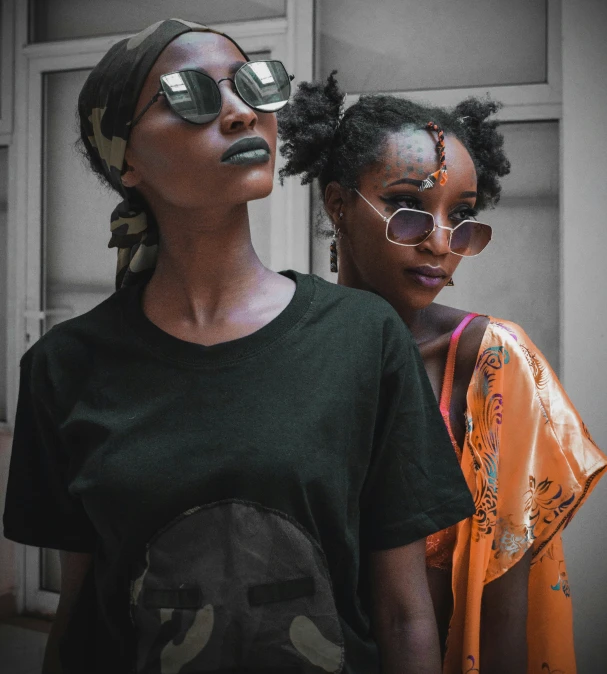 two women standing next to each other wearing sunglasses