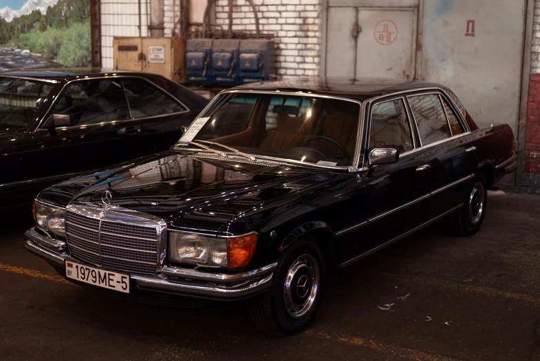 two parked cars sitting in an empty garage