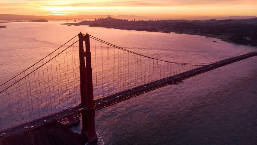 the golden gate bridge is seen as the sun sets