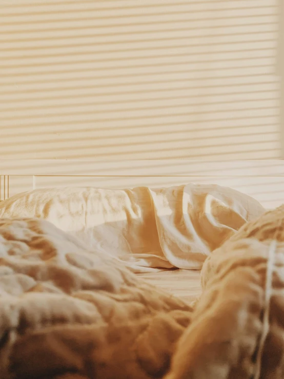 a view of a el bed with gold sheets and pillows