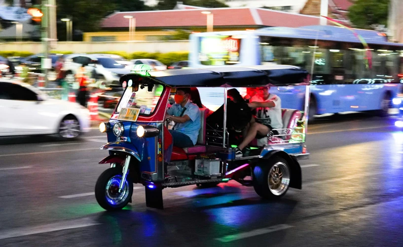 people in an open rickshaw car on the street