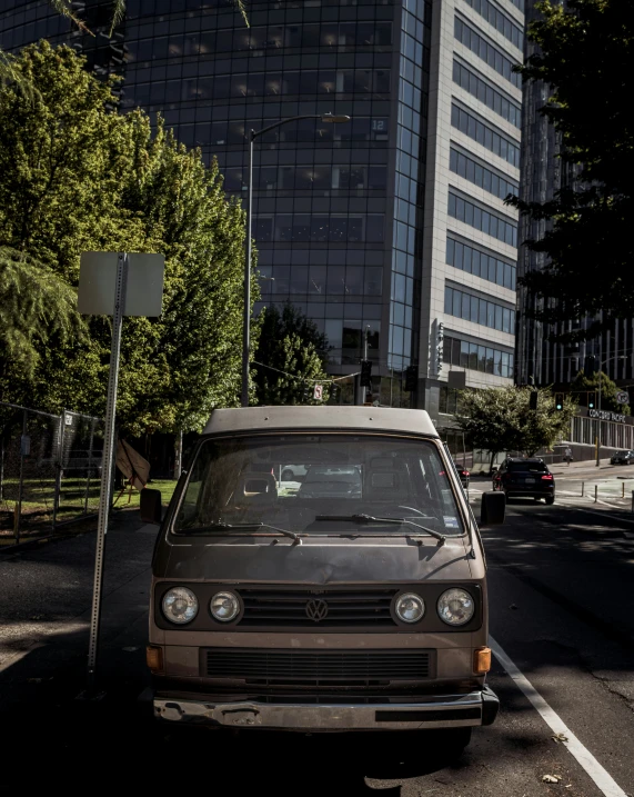 a volkswagen van parked on the side of the road in front of a building