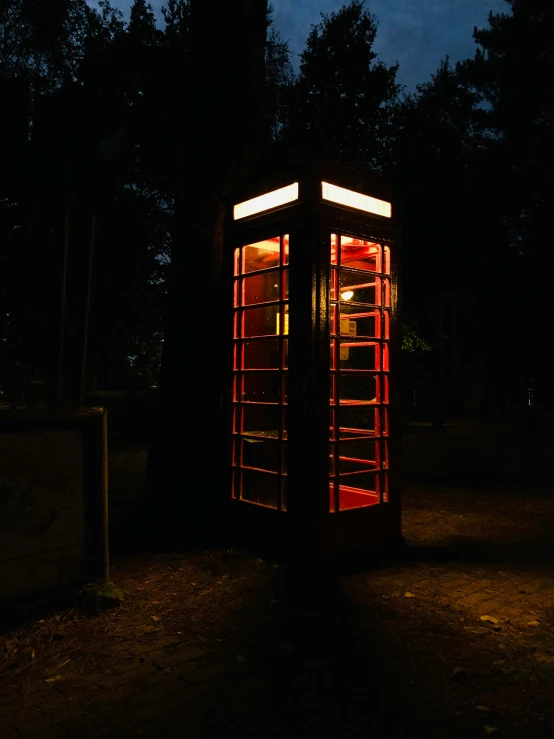 a light on a telephone booth at night