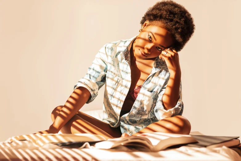 a woman sitting on the ground, reading a book and talking on the phone