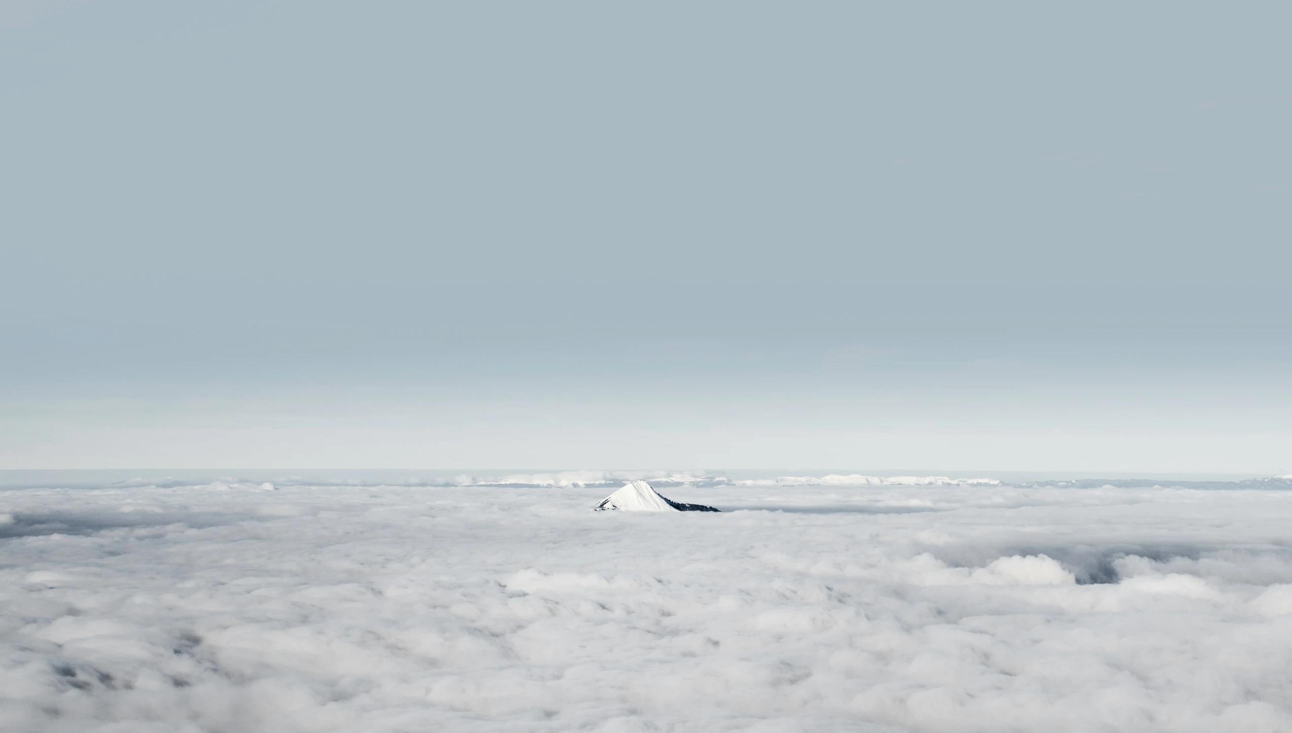 a plane flying high above the clouds below