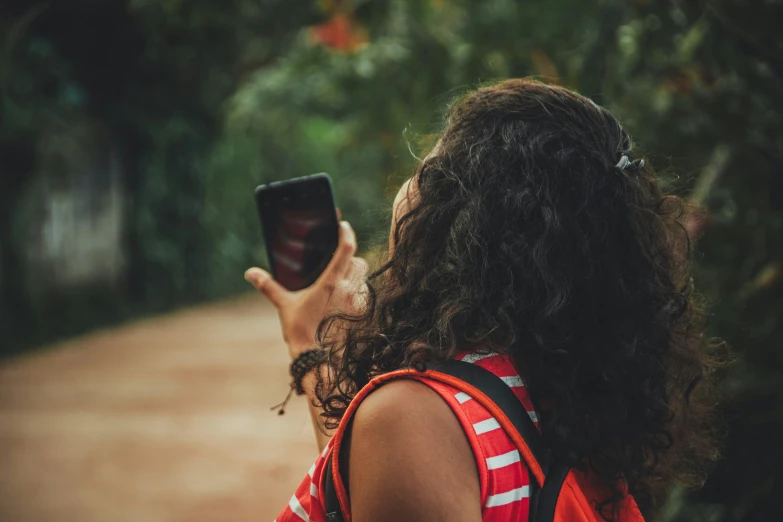 woman holding up and looking at soing on a cellphone