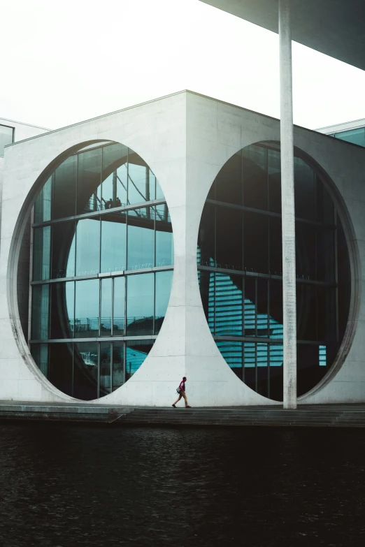 two people walking next to two circular windows