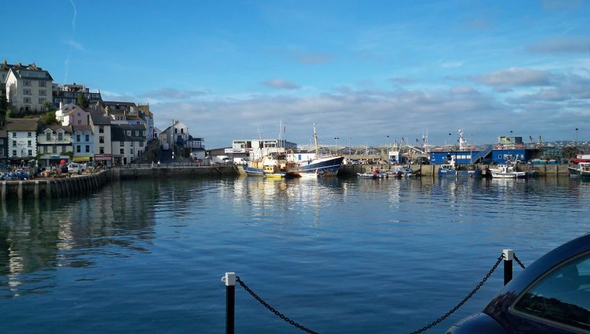 the cars are parked along the side of the harbor