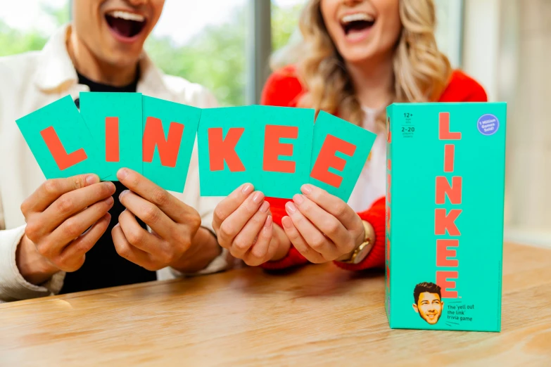 two people are smiling behind a linker on the table