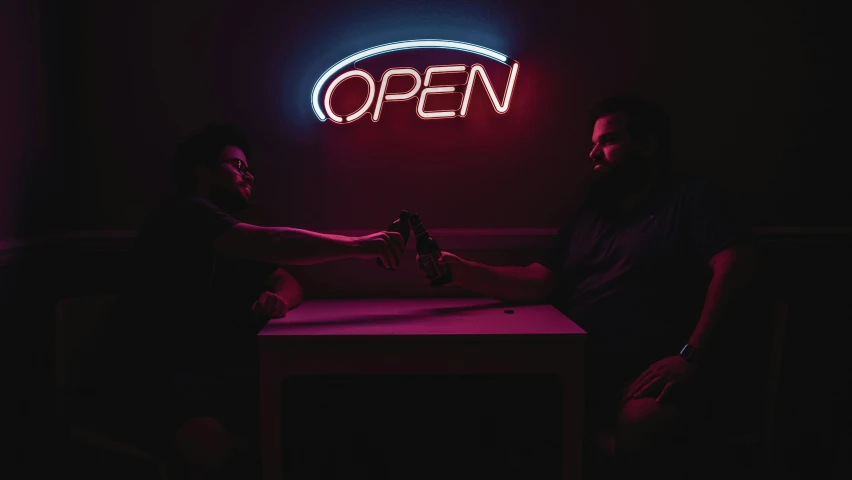 two men sit around in a darkened room