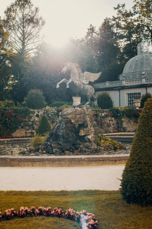 a garden with an outdoor fountain and building with turrets