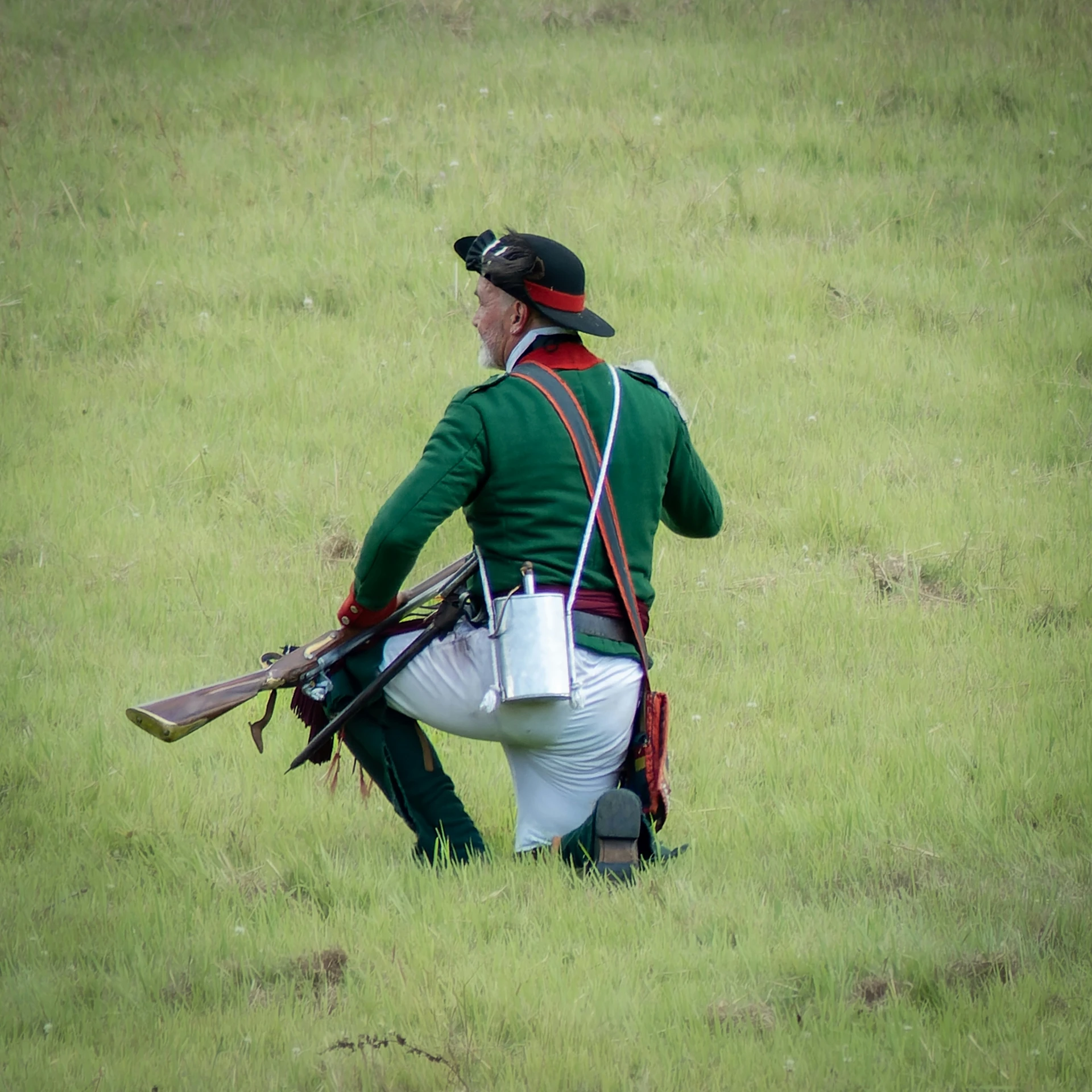 a man is kneeling in a grassy field