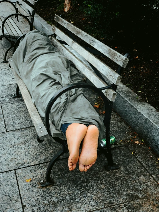 a person sitting on a bench with their legs extended