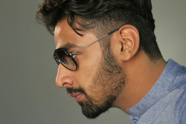 a man in sunglasses on his left ear looking down