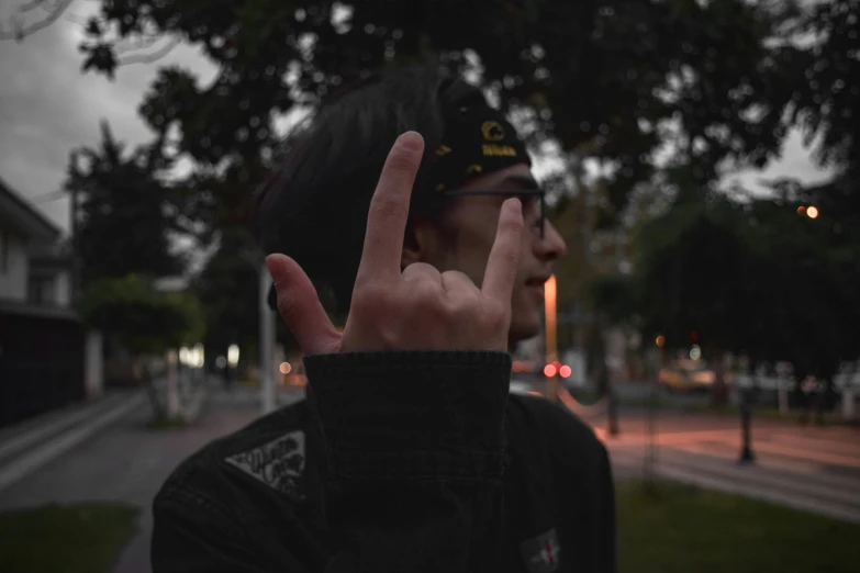 man with hand peace sign at the top of his head