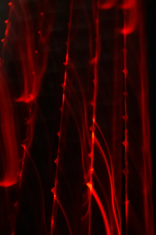 a very dark looking red background with a bunch of light streaks on it