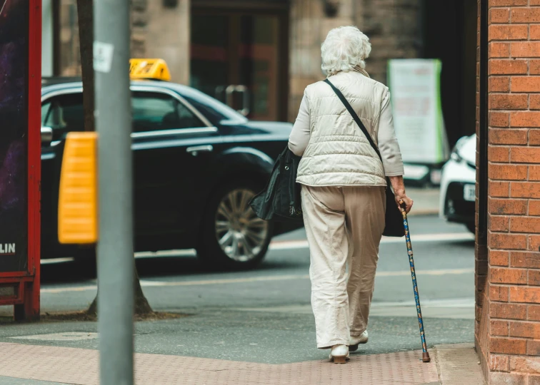 a woman wearing an old fashioned outfit walking down a street