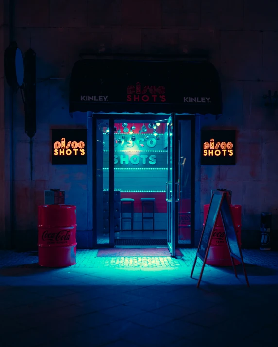 neon signs on the side of a restaurant with soda cans lit up