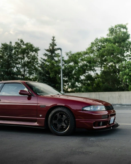 this is a maroon sport car in a parking lot