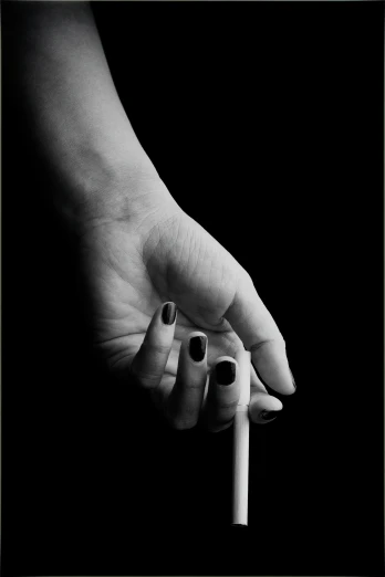 hand with two fingers reaching towards a cigarette