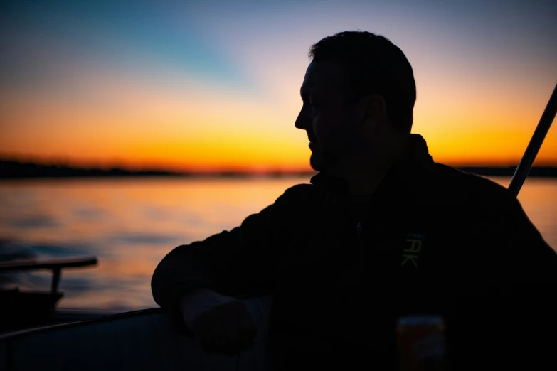 the silhouette of a man in front of a sunset