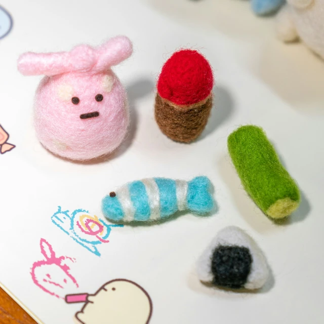 toy animals made with felt are on top of paper