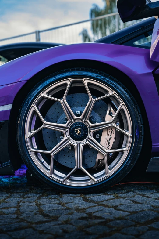 an expensive purple sports car with a large rear wheel